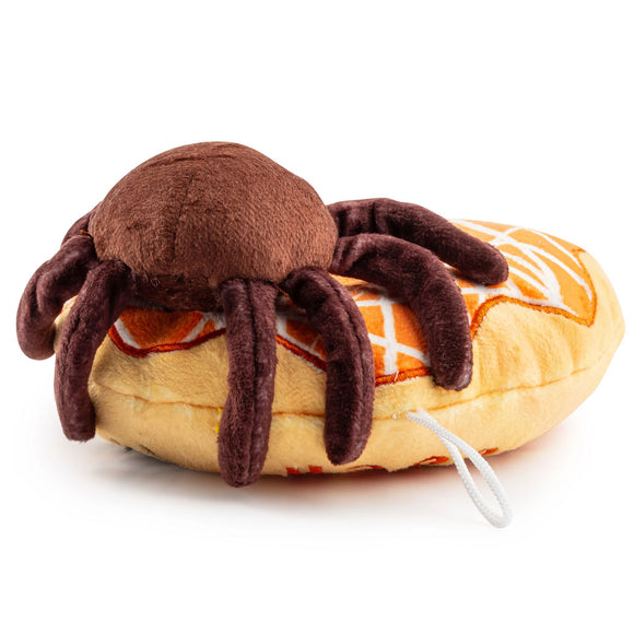 Plush toy spider on a bagel with a white background