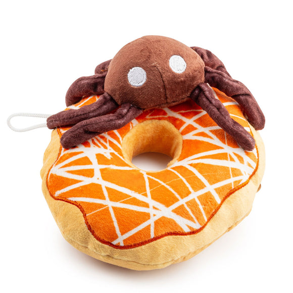 Plush toy resembling a spider on a donut with orange icing and white spider web design.
