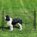 Dog standing inside a black metal pet playpen on grass