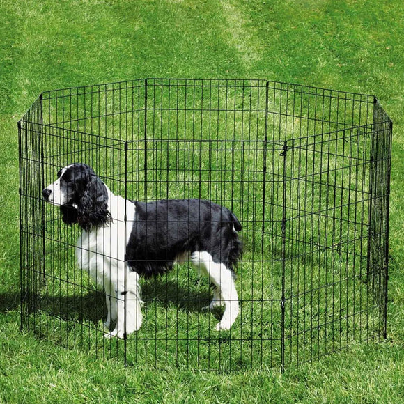 Dog standing inside a black metal pet playpen on grass