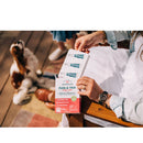 Person holding a box of Vectra flea and tick treatment for pets on a wooden floor with a dog in the background.