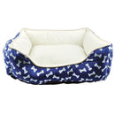 Dog bed with blue bone pattern and white interior on a white background