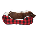 Dog lying in a red and black checkered pet bed on a white background