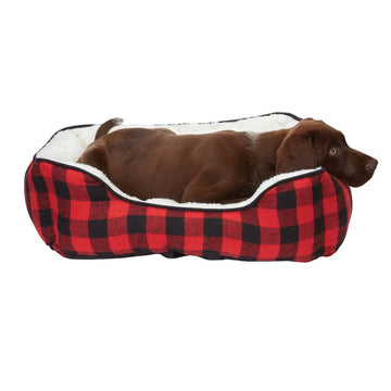 Dog lying in a red and black checkered pet bed on a white background