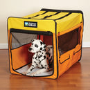 Dog inside a yellow and orange Guardian Gear pet crate on a wooden floor.
