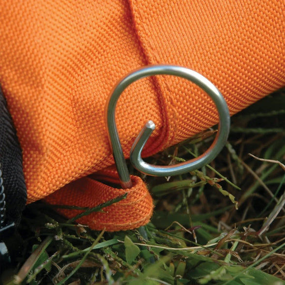 Metal carabiner attached to an orange rope on grass