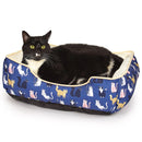Black cat lying on a blue pet bed with cat illustrations