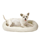 Dog lying on a fluffy white pet bed against a white background