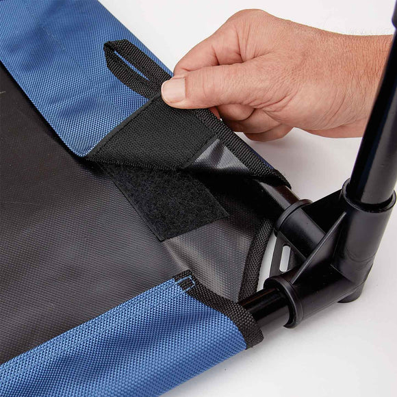 Hand adjusting a black strap on a blue and gray bag against a white background