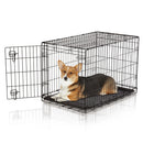 Dog inside a black metal crate on a white background