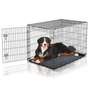 Dog lying inside a black metal dog crate on a white background