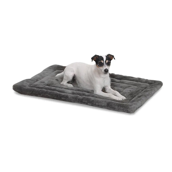 Dog lying on a gray pet bed against a white background