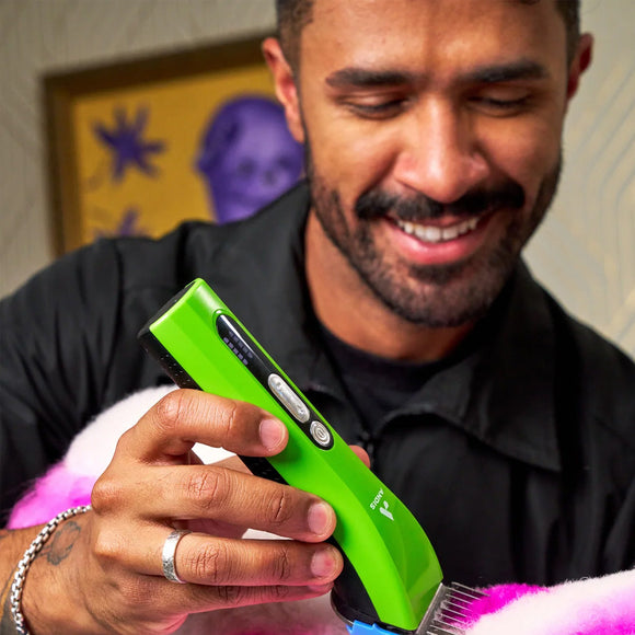 Man holding a green electronic device with a colorful background
