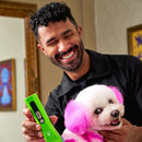 Man holding a dog with pink fur and a green device in a room.