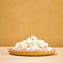 Wooden plate with white cubes on a beige background