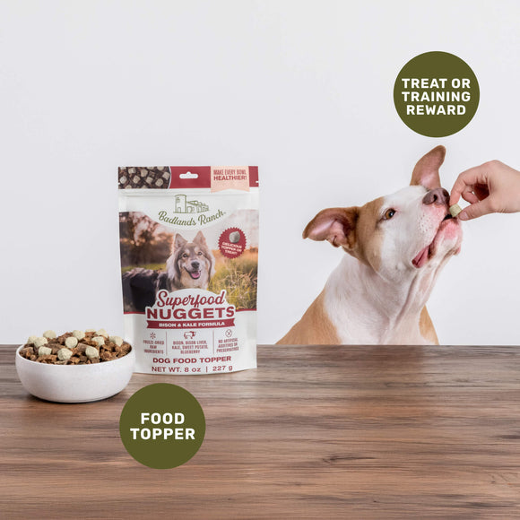 Dog food topper package with a dog eating from a hand on a wooden table.