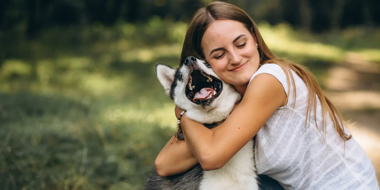 girl hugging her dog in the park