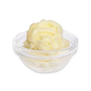Glass bowl with yellow butter on a white background