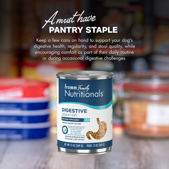 Can of Fromm Family Nutritionals dog food with text about digestive health on a blurred pantry background.