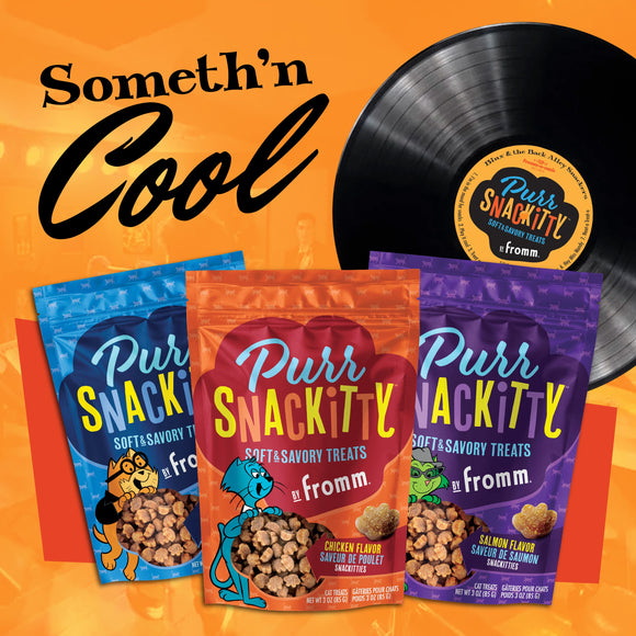 Purr Snackity cat treats packages with a vinyl record on an orange background