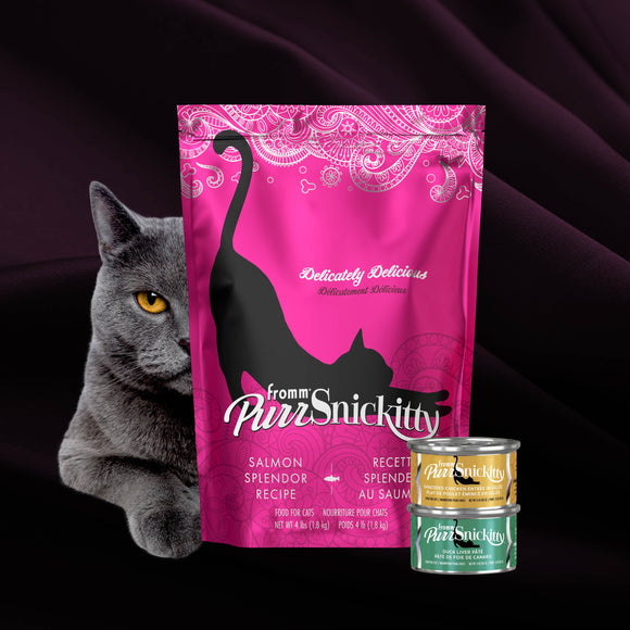 Pink package of PurrSnickitty cat food with a gray cat and two cans on a dark background