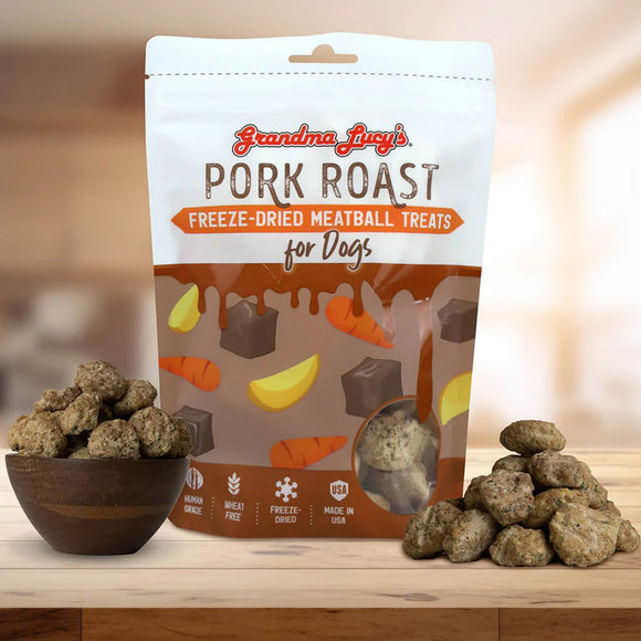 Bag of Grandma Lucy's Pork Roast freeze-dried meatball treats for dogs on a wooden surface with treats displayed.