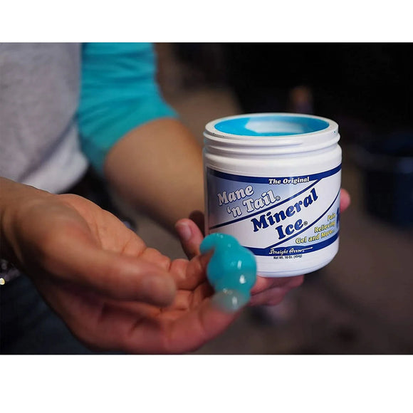 Hand holding a container of Mane 'n Tail Mineral Ice equine therapy gel