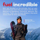 Person holding a snowboard and a dog with mountains in the background, featuring Nulo pet food advertisement.