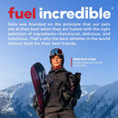 Person holding a snowboard and a dog with mountains in the background, featuring Nulo pet food advertisement.