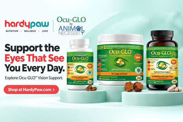 HardyPaw and Ocu-GLO by Animal Necessity vision support supplement products displayed on light teal pedestals against a pale mint background. The products include a small white bottle, a medium white jar, and a dark amber bottle, all with green and yellow labels.