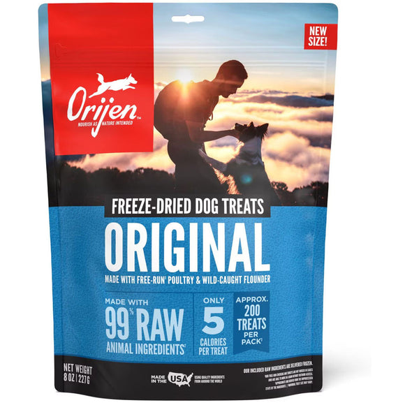 Orijen freeze-dried dog treats packaging with a sunset scene and silhouette of a person and dog.