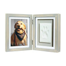 Double picture frame with a photo of a dog on one side and a paw print on the other, on a white background.