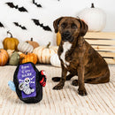Dog sitting next to a Halloween-themed toy with pumpkins and bats in the background