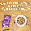 Stella & Chewy's Carnivore Cravings pet food packages with a bowl of pet food on a wooden surface.