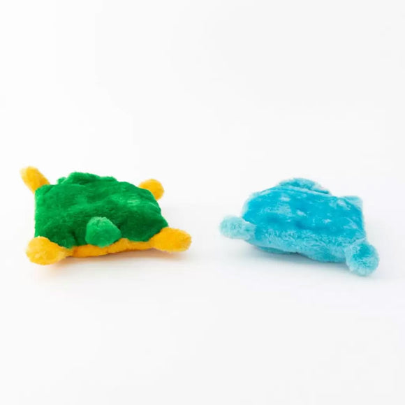 Two small turtle-shaped toys, one green and yellow, the other blue, on a white background.