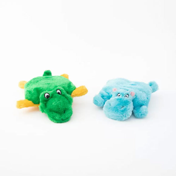 Two plush toys, one green and one blue, on a white background
